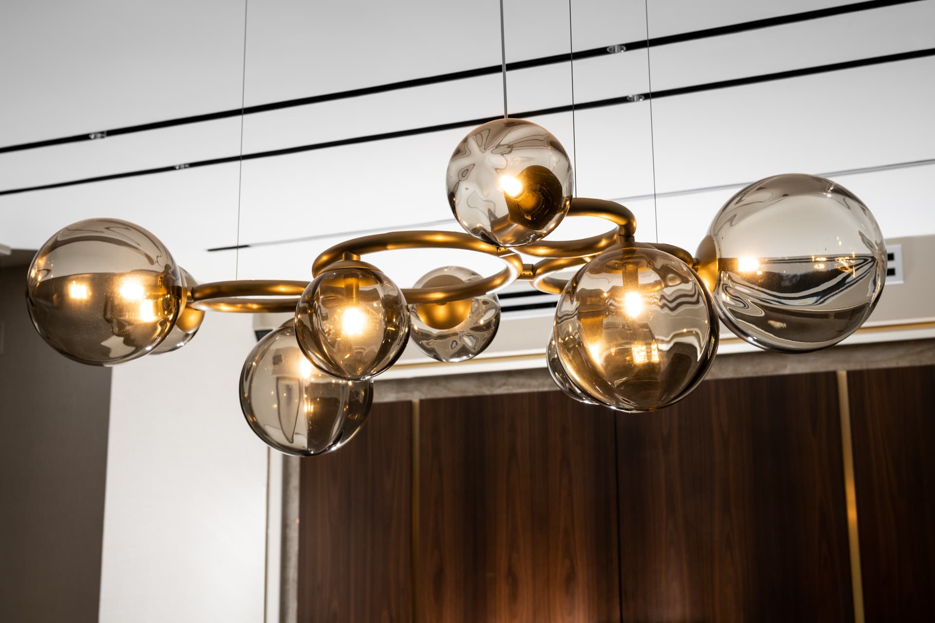 Industrial chrome-and-glass pendant above green-felt billiard table