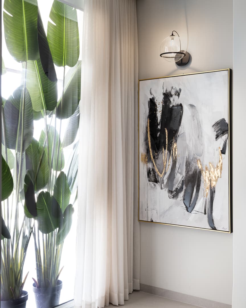 Carved stone basin on walnut vanity with backlit oval mirror
