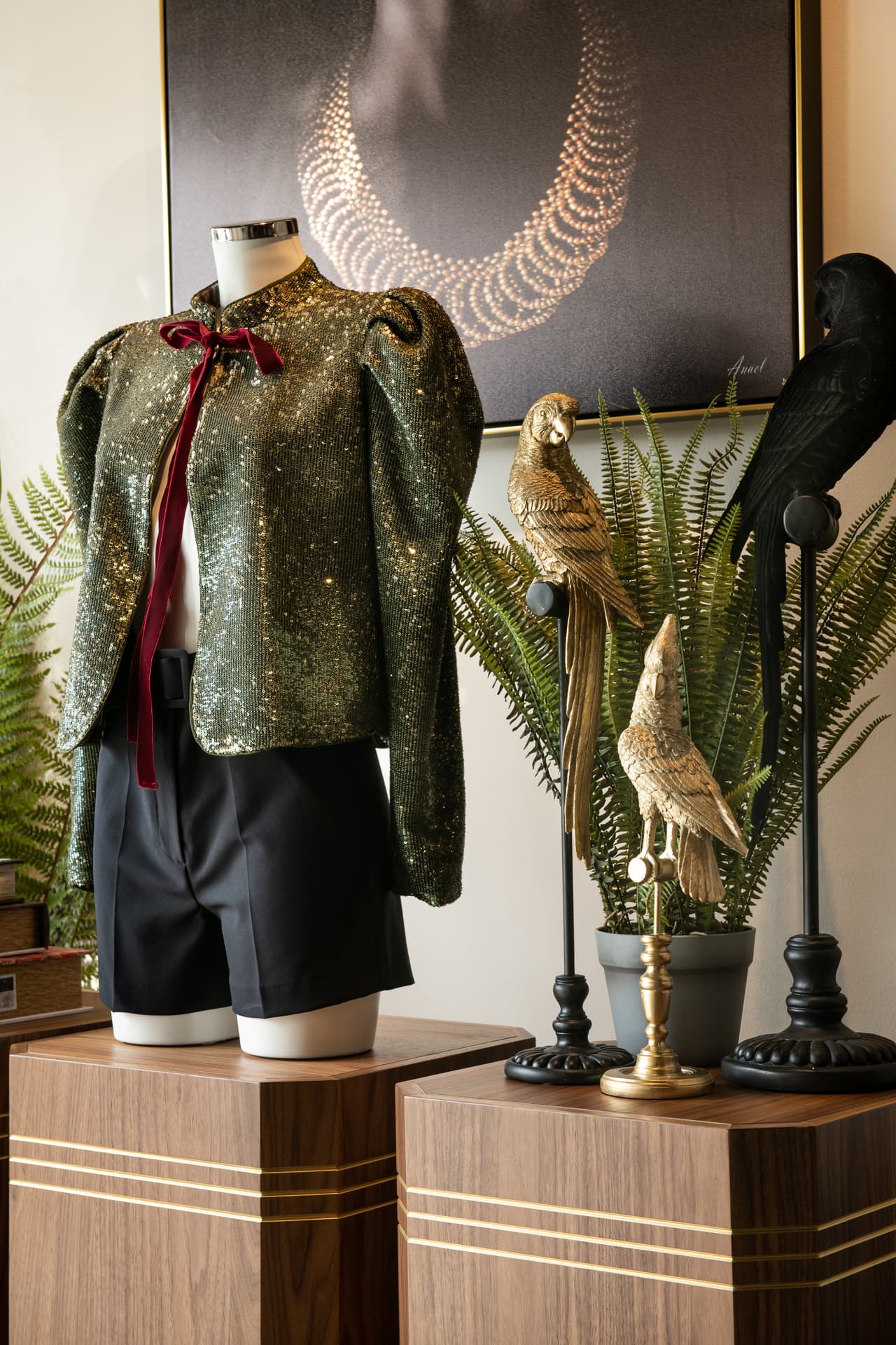 Gold-framed walnut wardrobe alcove with vintage luggage display