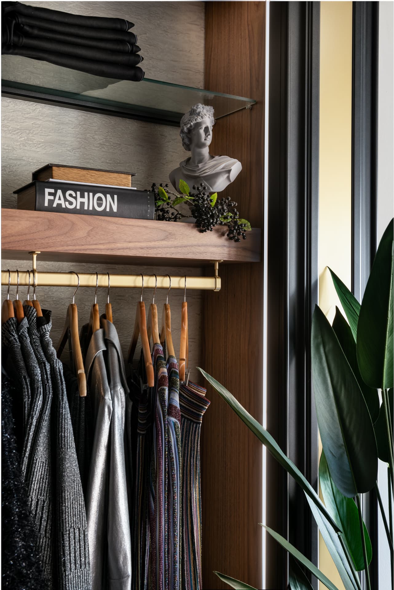 Walnut pedestals with styled mannequins beneath African art portrait