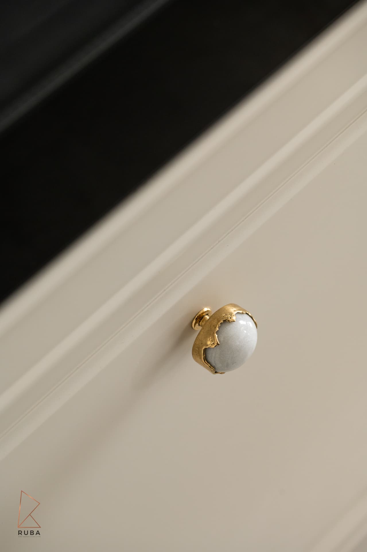 Marble and gold cabinet knob — macro close-up