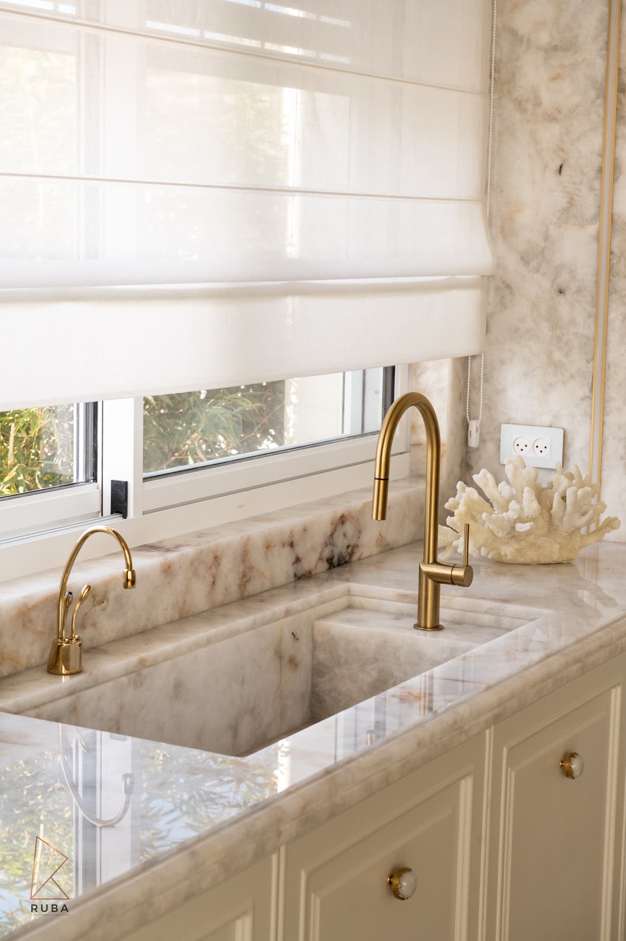Gold faucet with onyx countertop and coral sculpture