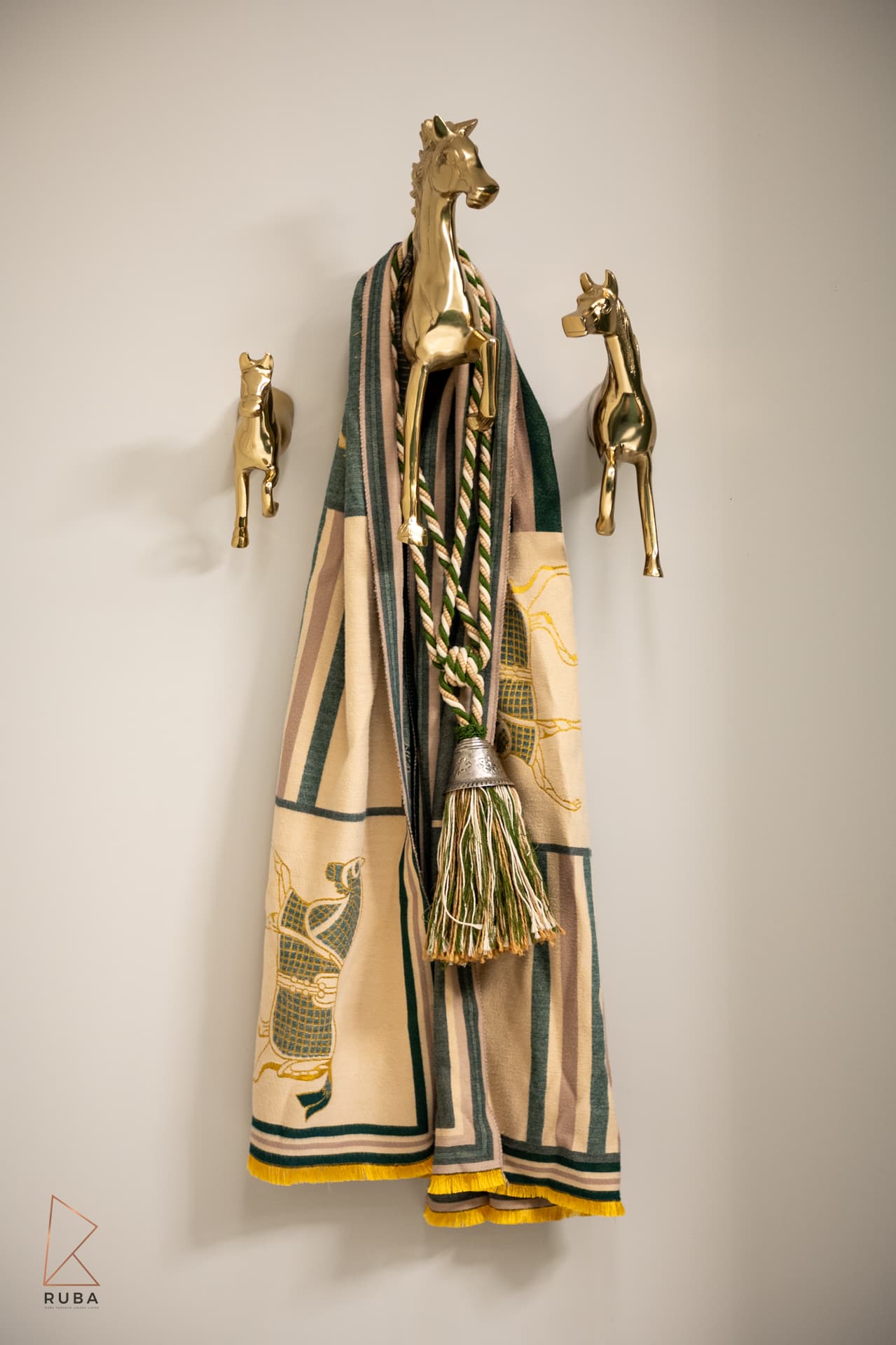 Gold horse-head wall hooks with designer scarf and tassel