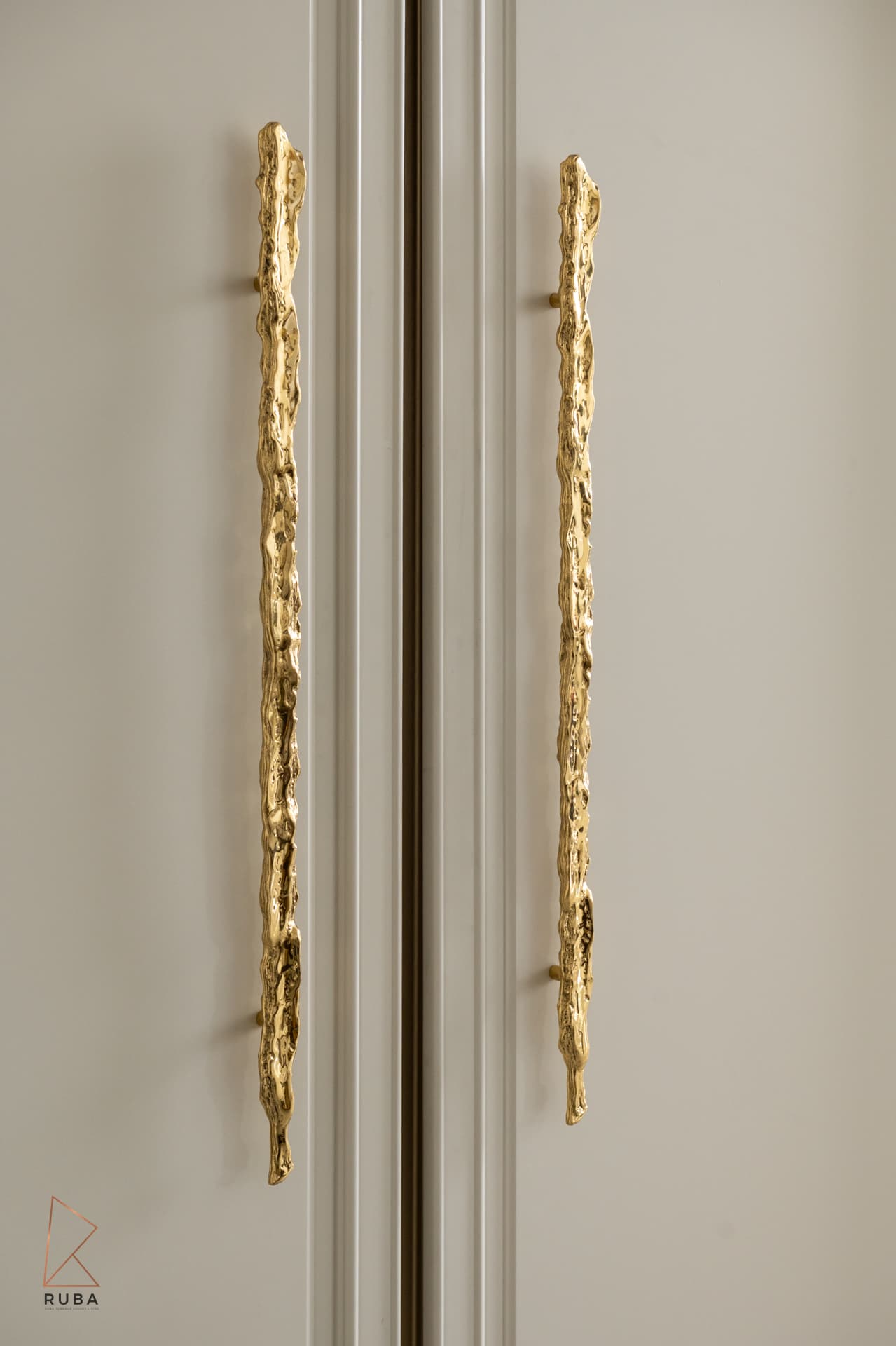 Hammered gold branch-form door pulls on paneled cabinet