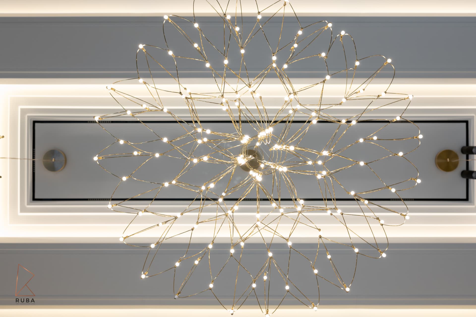 Cascading teardrop crystal pendant over white marble dining table