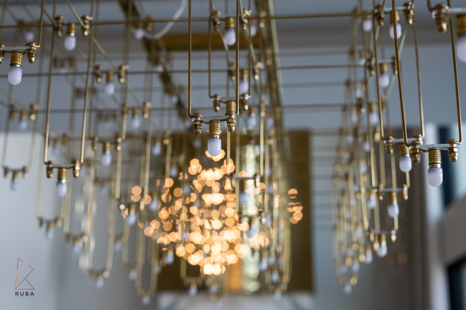 Amber glass vessel sink in walnut arch-framed vanity alcove