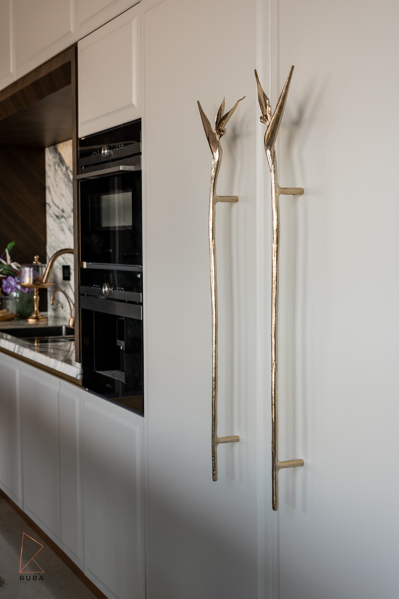 Fluted walnut island with gold base trim and marble countertop