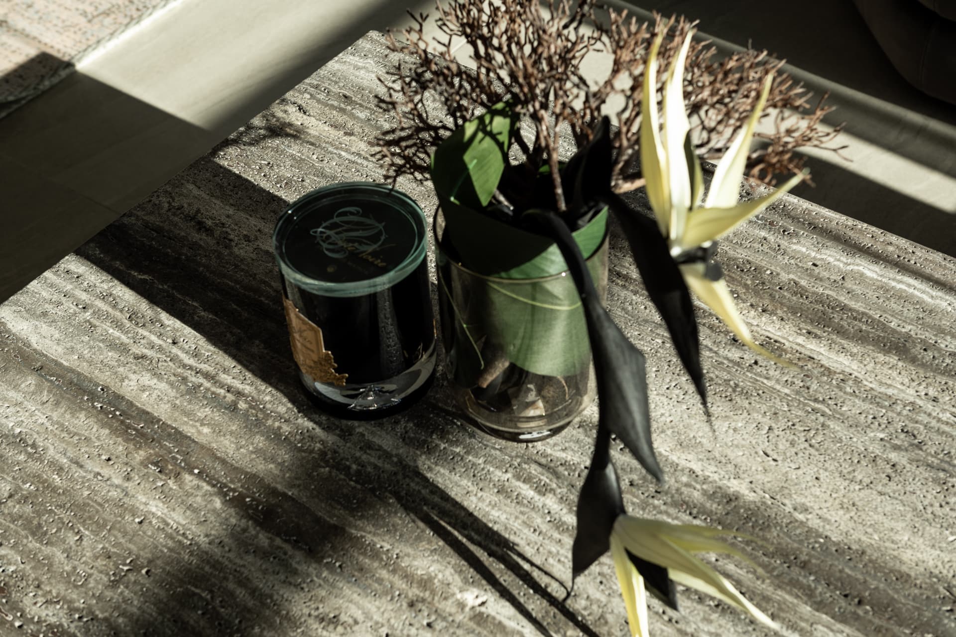 Travertine tabletop with smoked candle and botanical arrangement