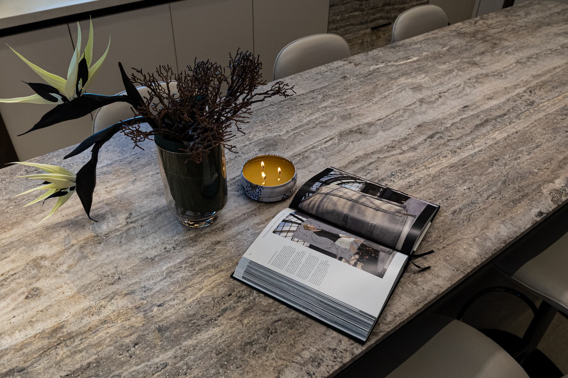 Travertine dining surface with horizontal veining and open magazine