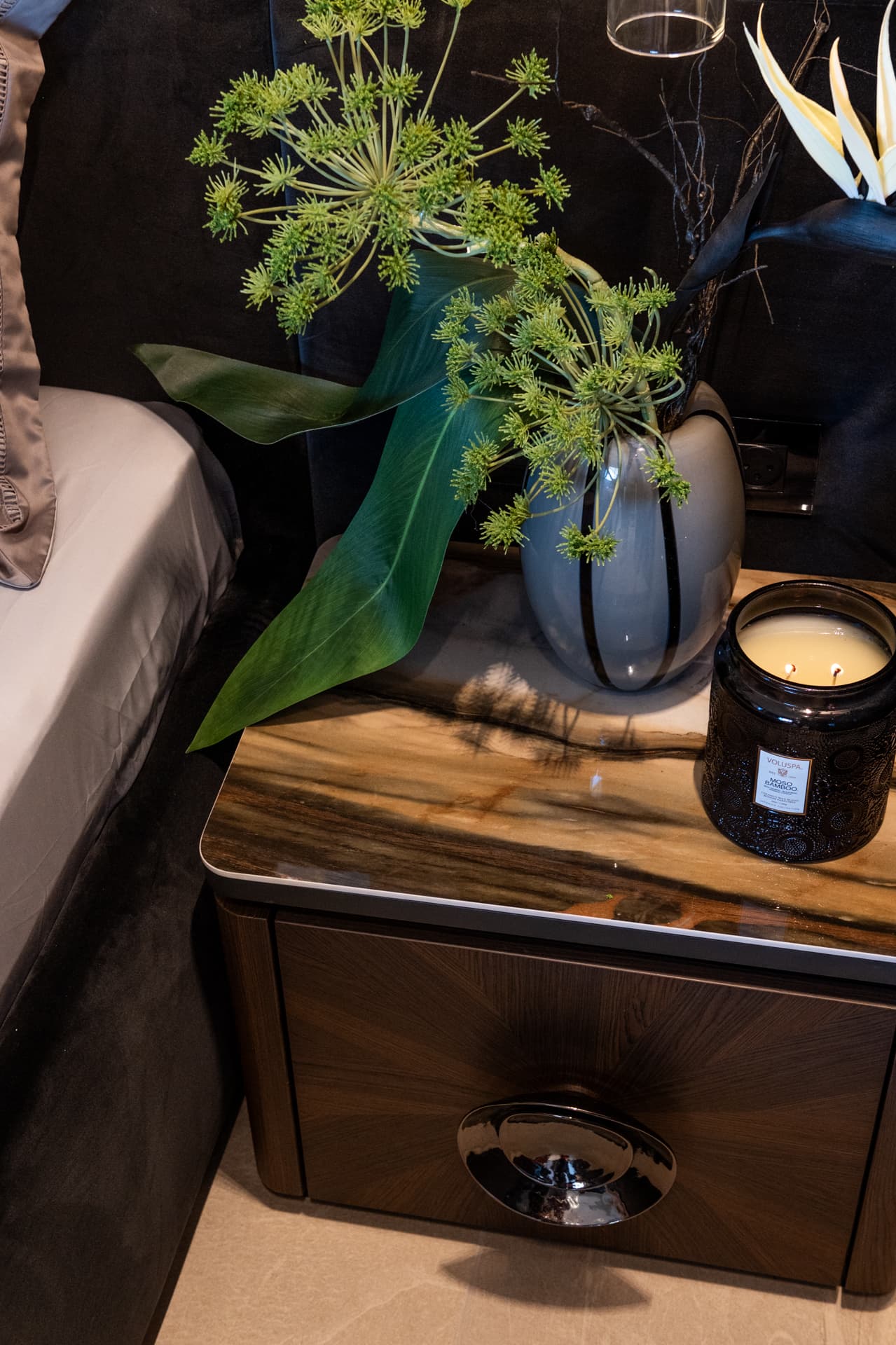 Radial-veneer nightstand with polished chrome ring pull and smoked vase