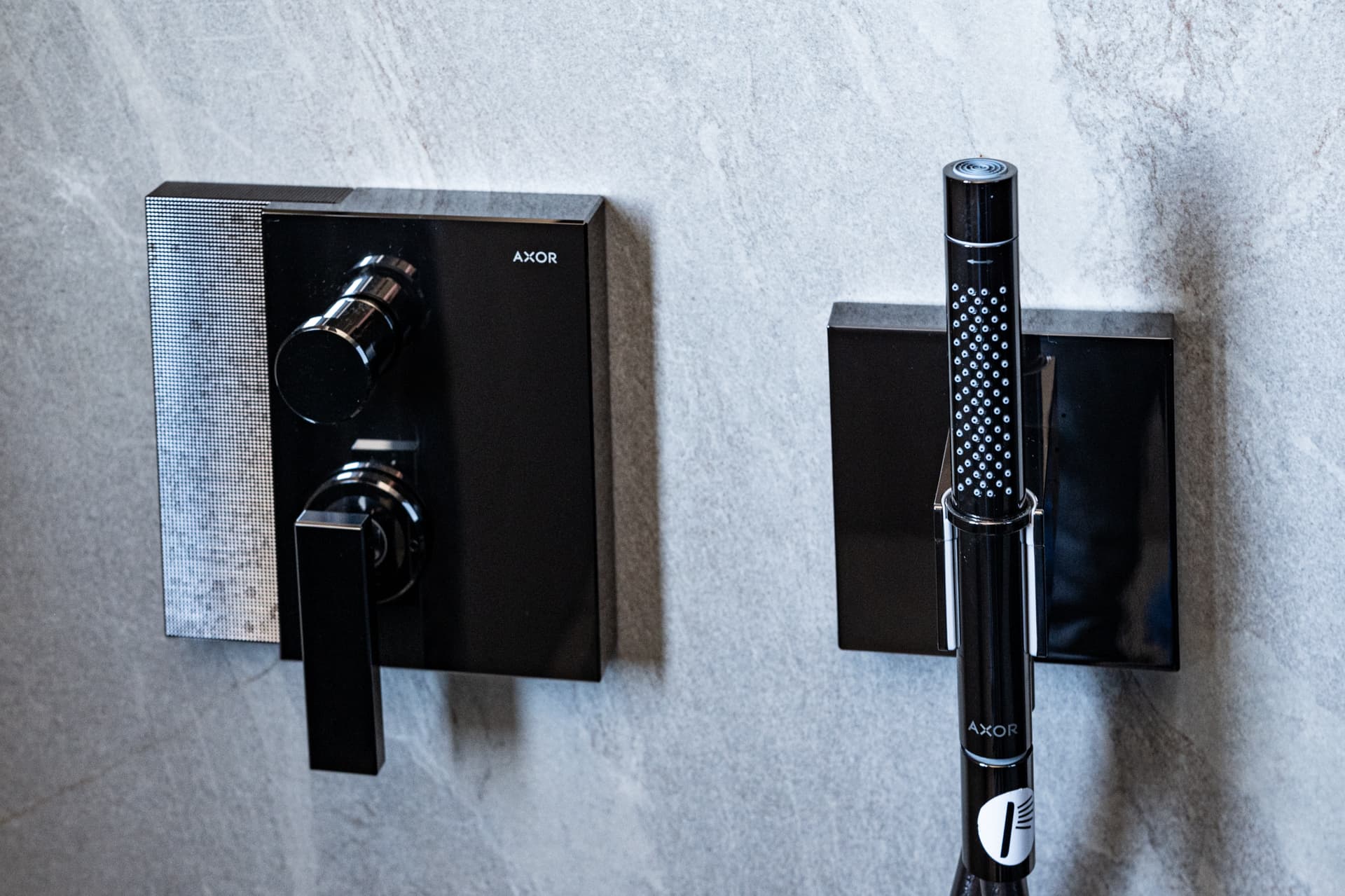 Black Axor thermostatic shower controls on grey veined stone