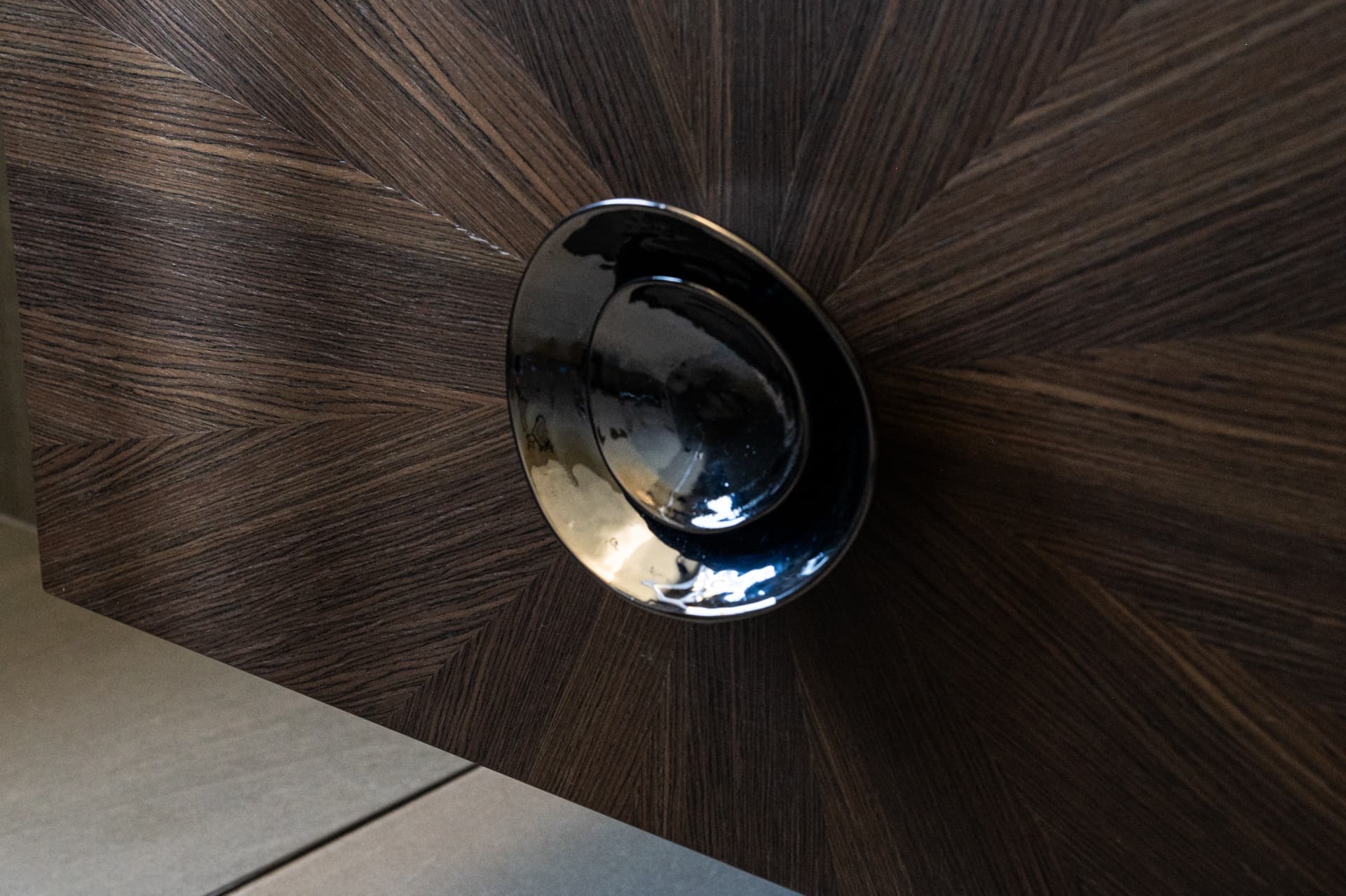 Polished chrome concave pull on sunburst walnut veneer drawer