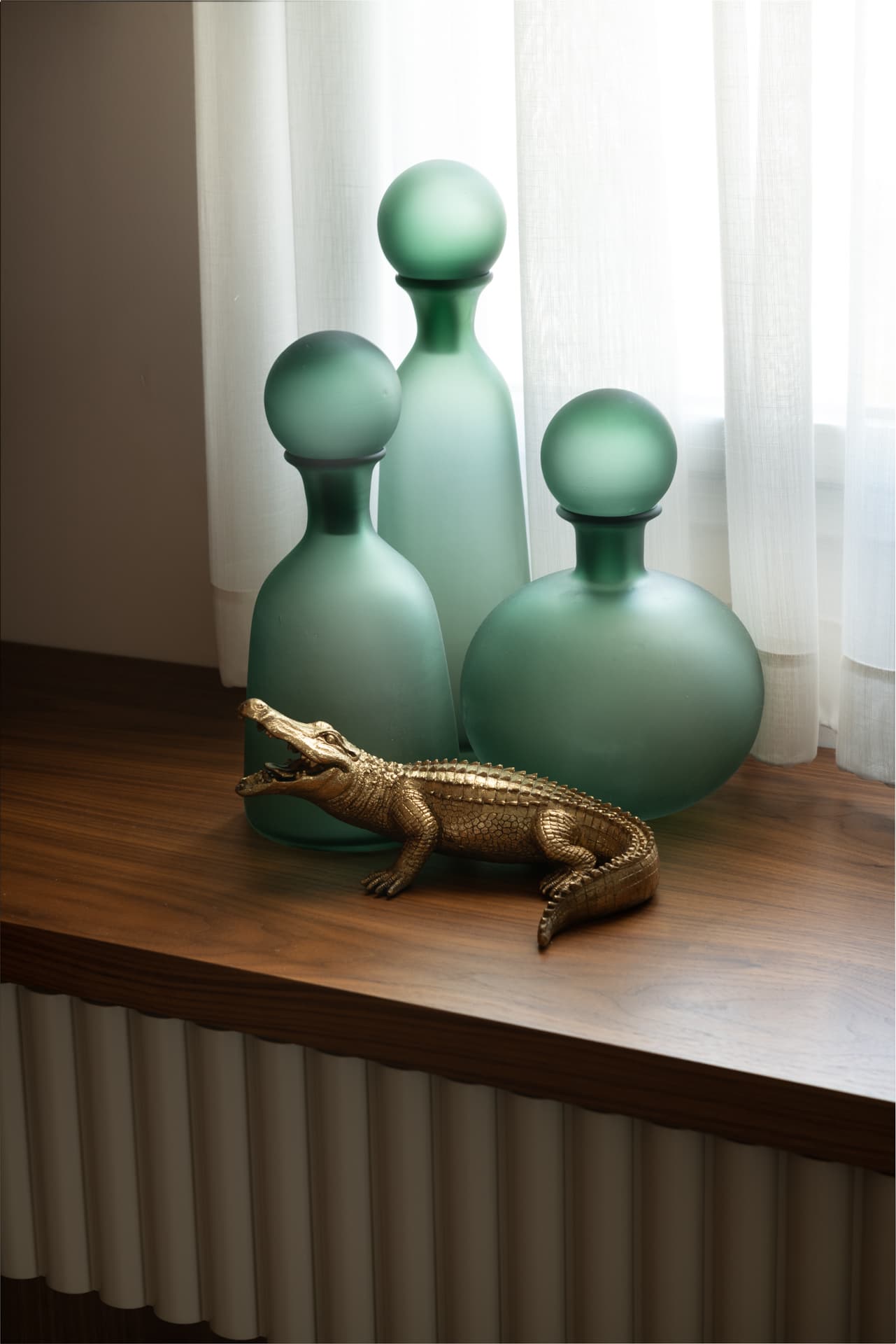 Rope-frame circular mirror with brass picture light on travertine