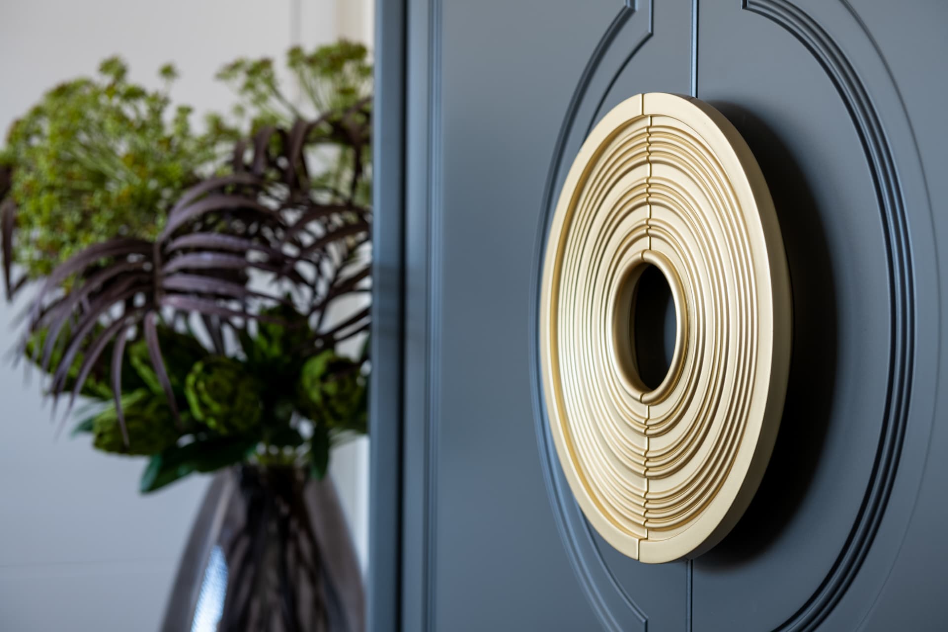 Abstract charcoal-and-gold painting between starburst wall sconces