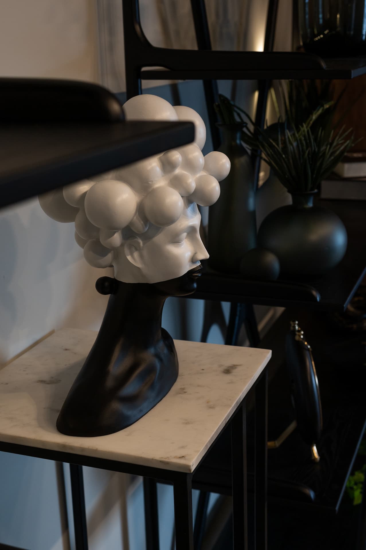 Walnut bar counter with dark teal leather stools and bronze pendant