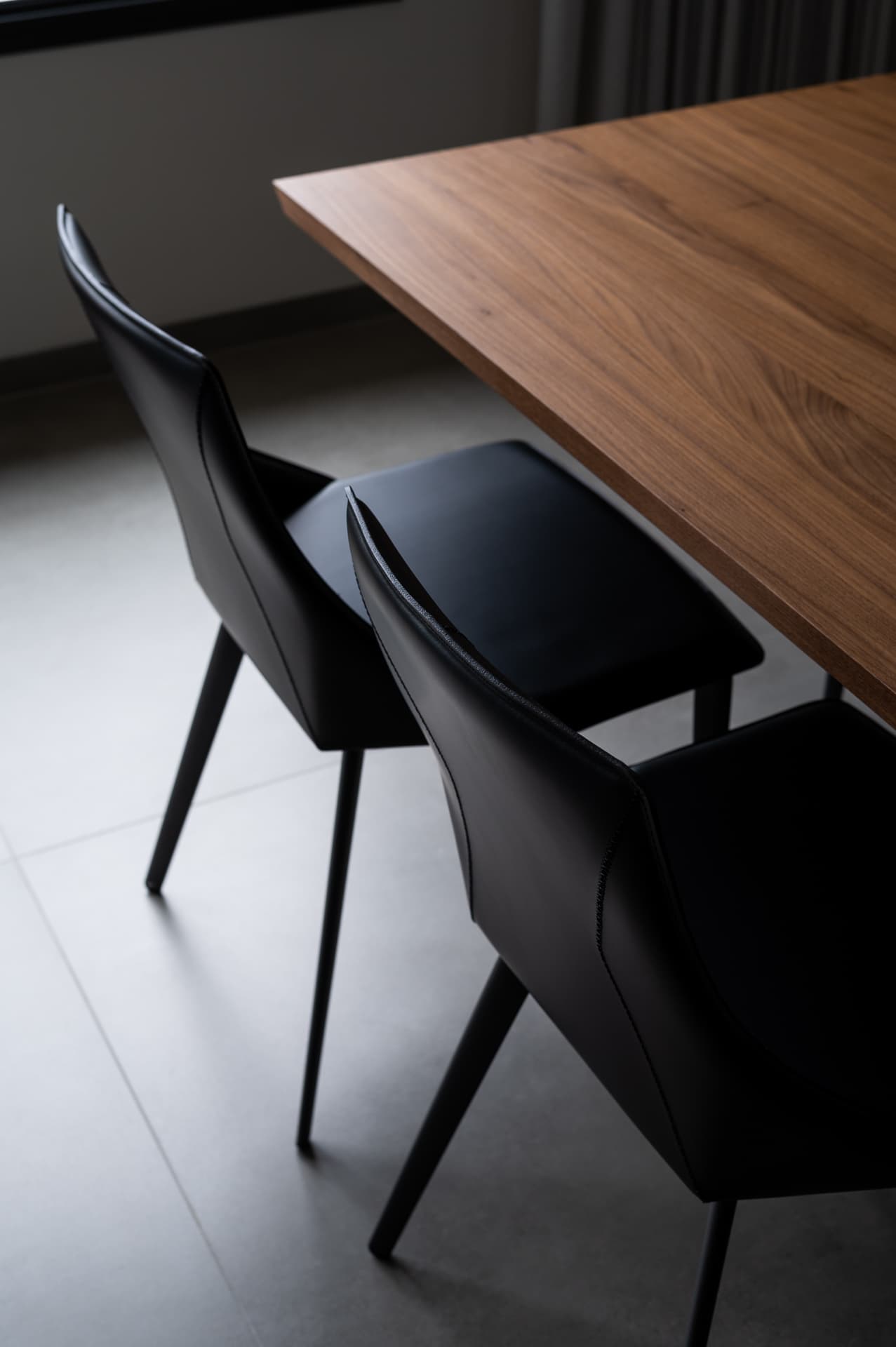 Charcoal leather swivel chair against dark overdyed rug