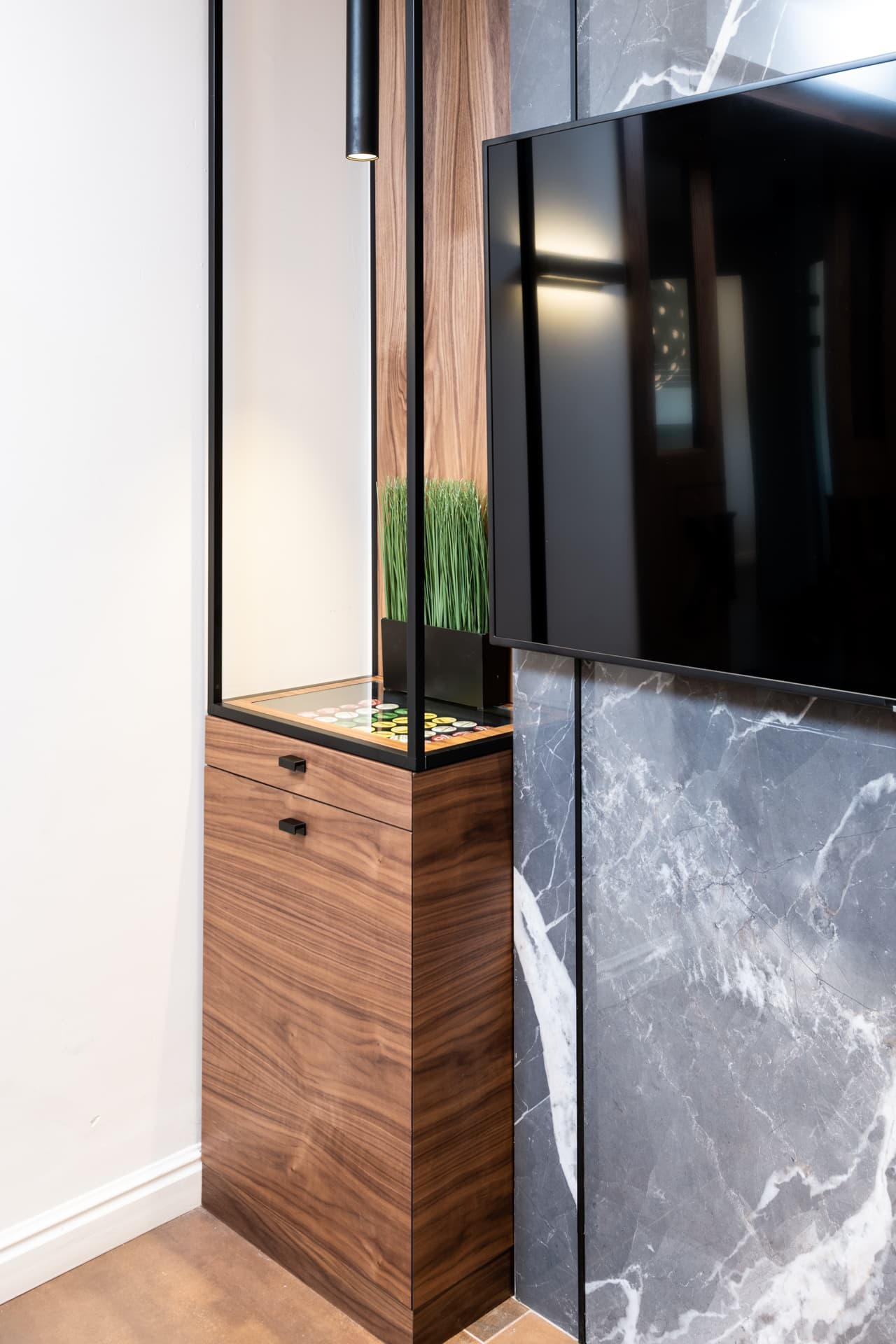 Black marble reception desk beneath triple concentric ring pendants
