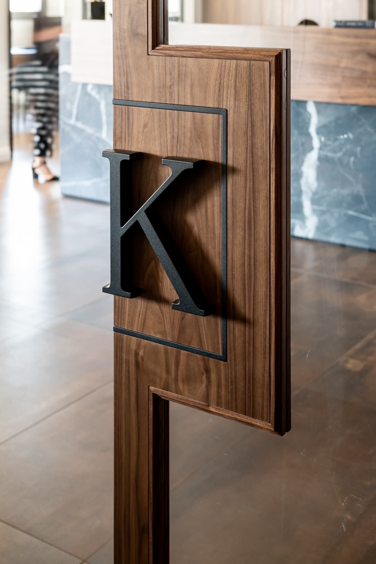 Branded walnut sliding doors with company initials cut-out