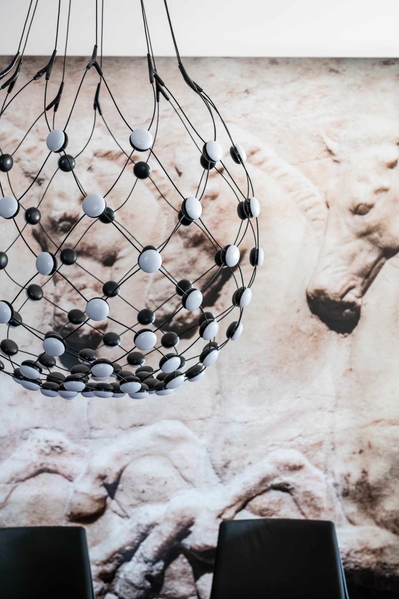 Sculptural wire chandelier before desert-landscape photograph