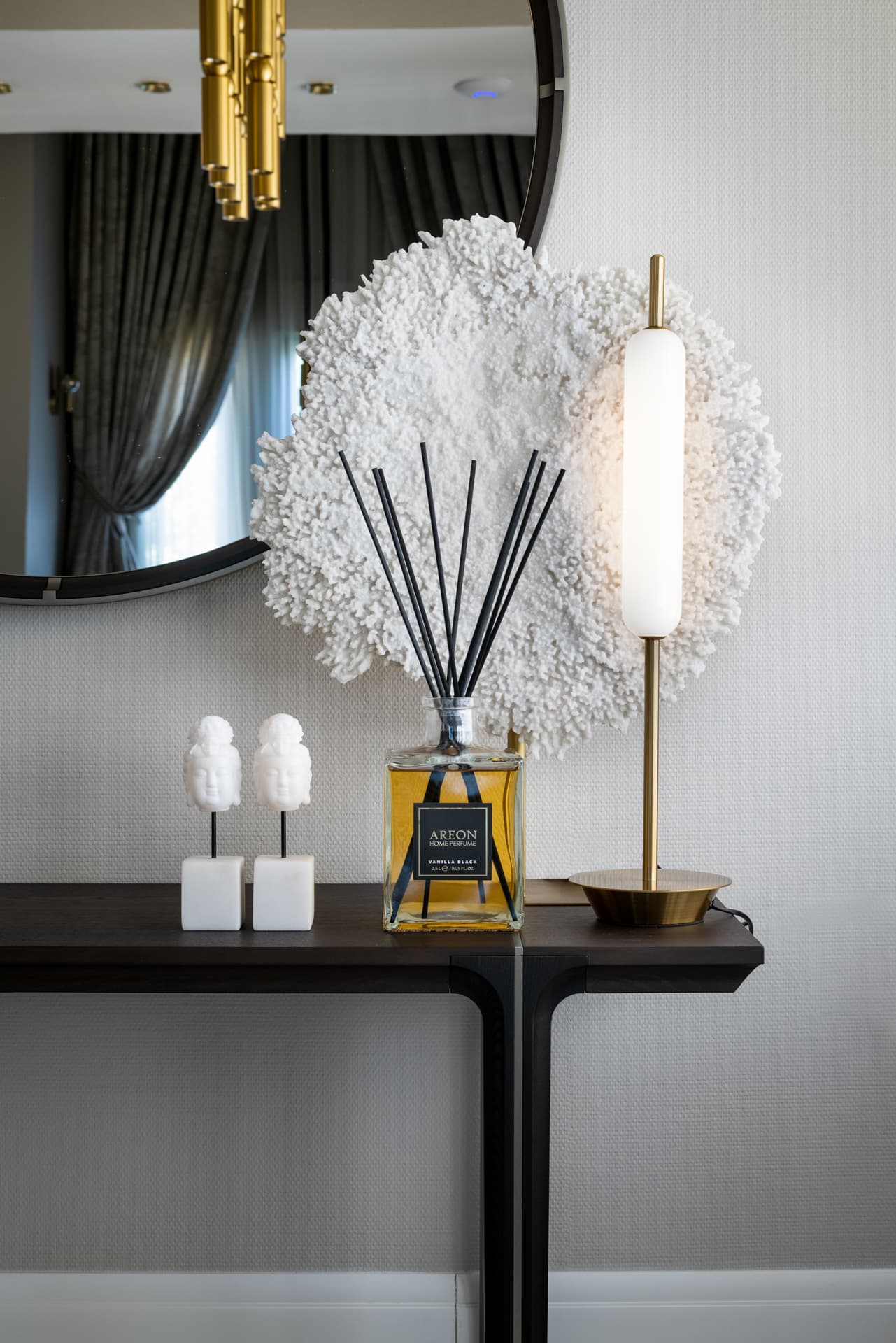 Cascading brass cylinder chandelier against diagonal walnut wall