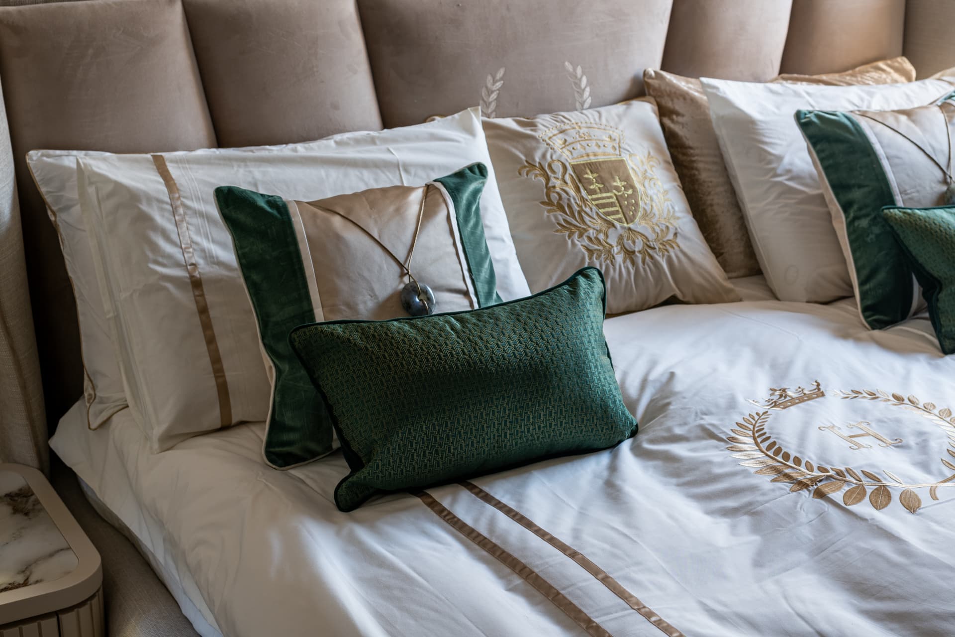 Grey winged headboard with emerald velvet accent cushions