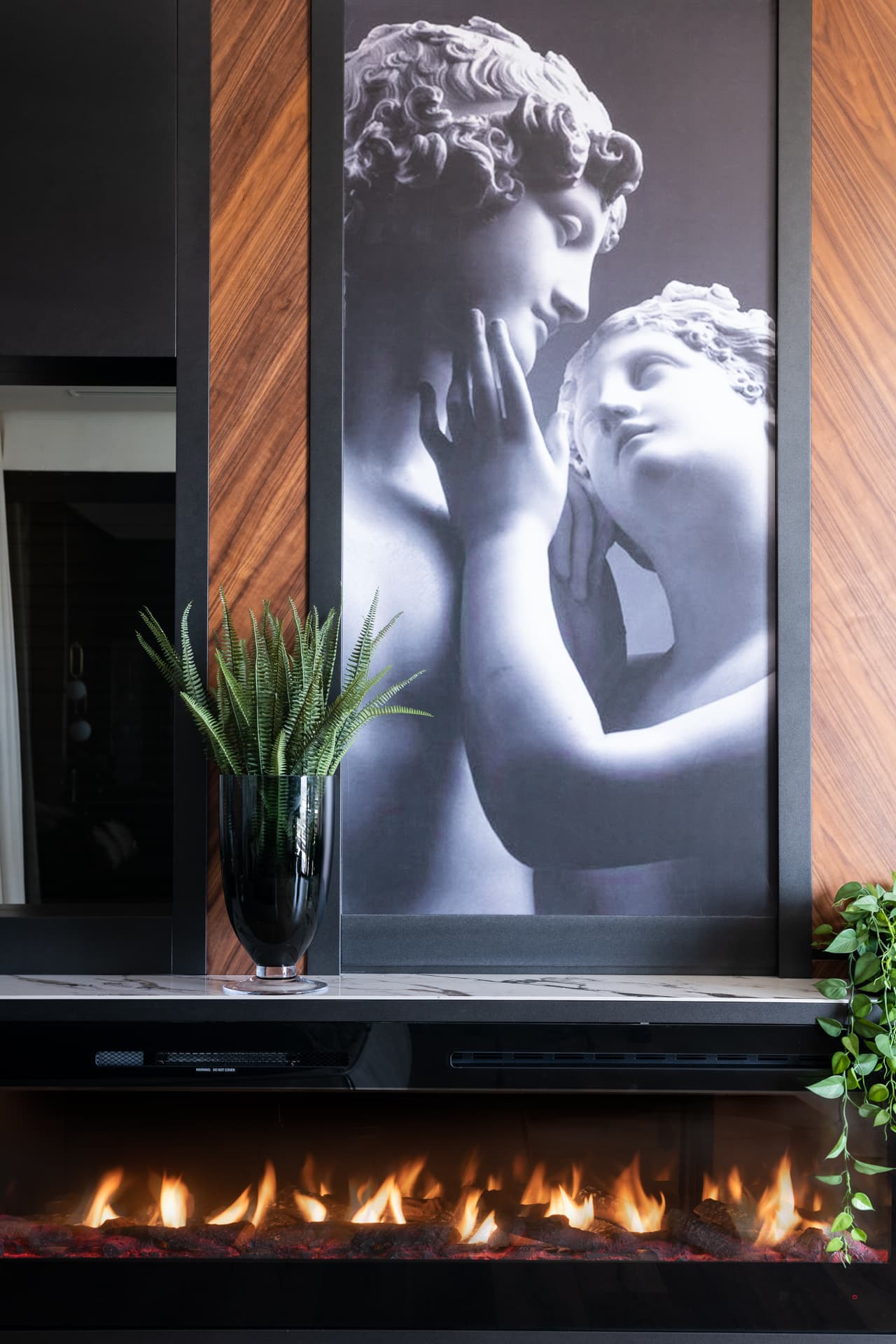 Globe pendant on gold stem between walnut headboard panels