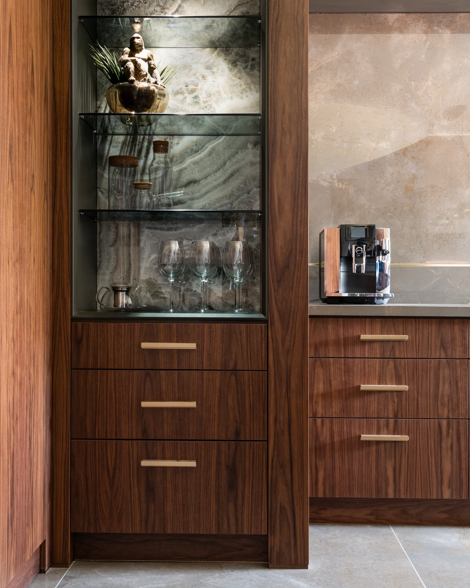 Bronze disc pendants on black linear track above concrete island