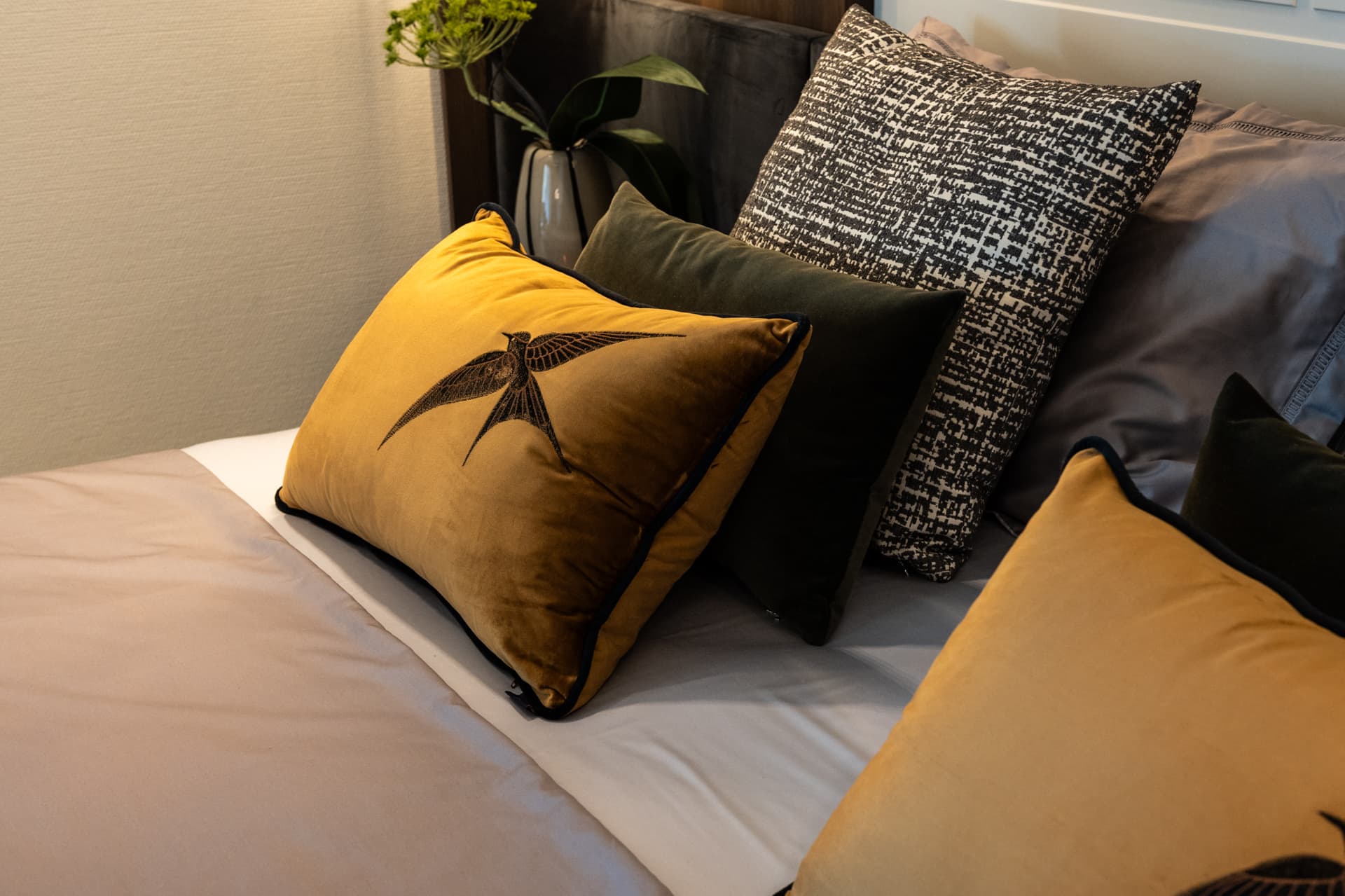 Amber velvet cushion with embroidered swallow on silk and tweed layers